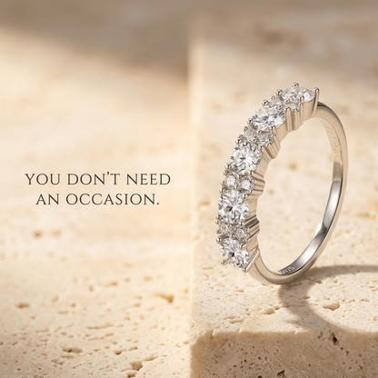 Velara Milano moissanite half-eternity ring on travertine surface, quiet luxury product photo